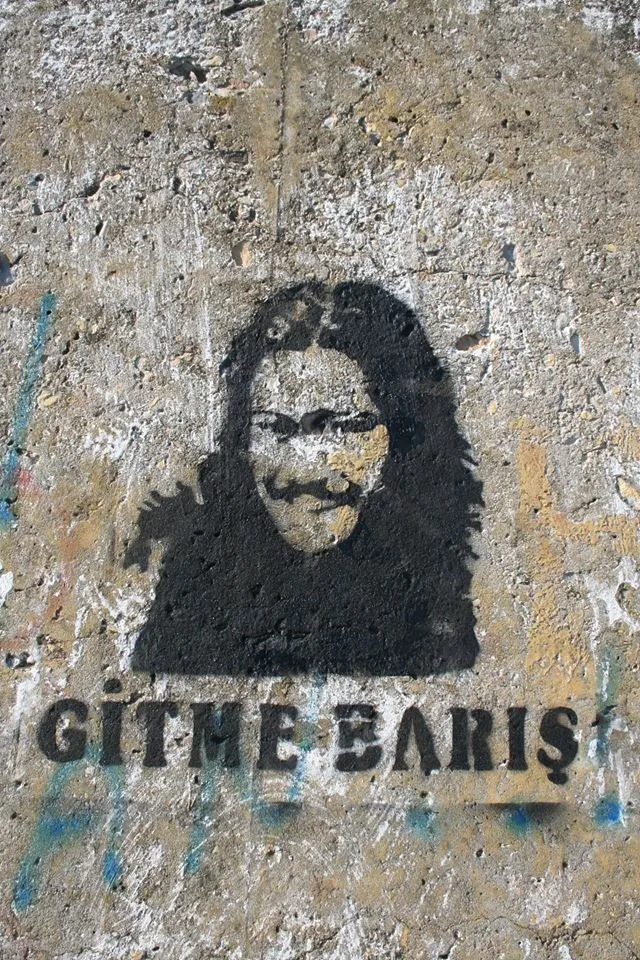 Mendirek duvarına yapılmış, "Gitme Barış" yazılı portre